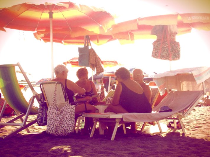 Old people playing cards on the beach. Fiumicino, Italy.